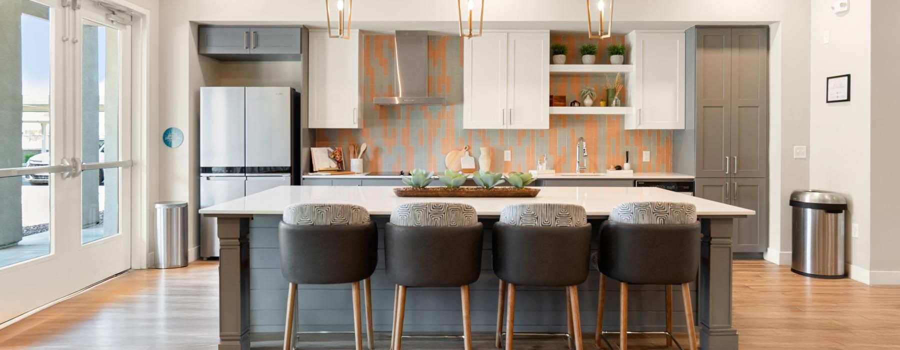 a kitchen with a bar and stools in clubhouse
